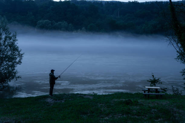 Man fishing on the mountain river at evening.
