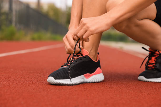 istock Woman tying shoelaces before training outdoors. closeup. Space for text 1954424278