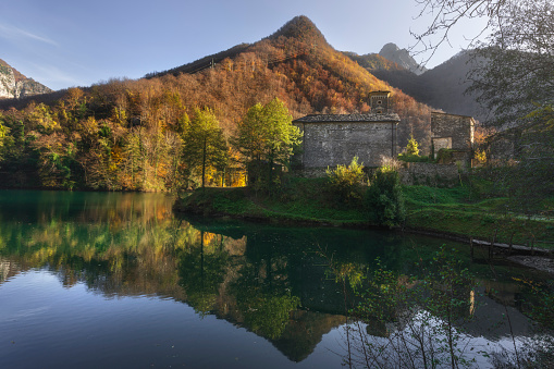 Isola Santa medieval village and lake in autumn foliage. Garfagnana, Tuscany, Italy.