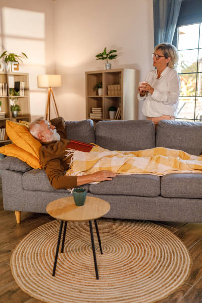 istock Man lying on the sofa, resting and casually chatting with his wife 1954457963