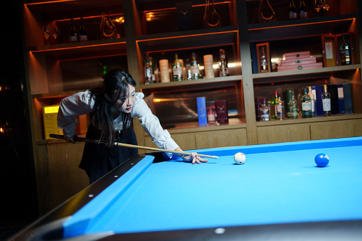 Beautiful girl playing billiards