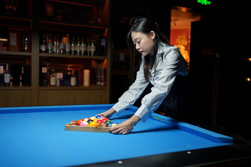 Young woman preparing for billiards