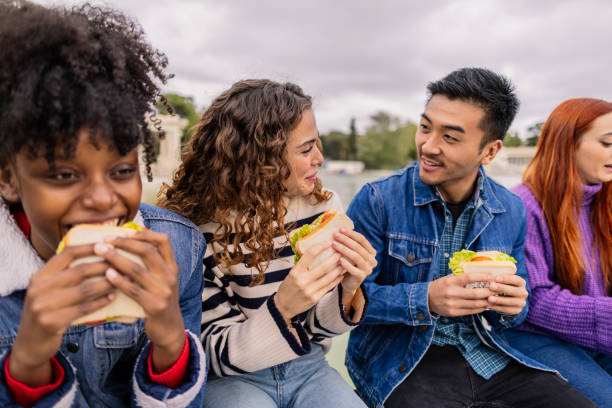 istock multiracial friends having a snack sandwich on their college break 1954496106