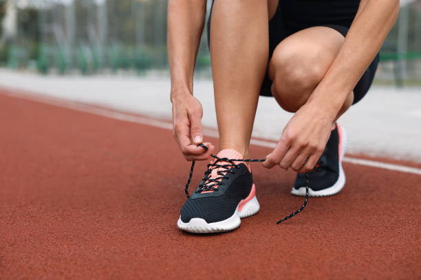 istock Woman tying shoelaces before training outdoors. closeup. Space for text 1954513181