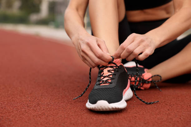 istock Woman tying shoelaces before training outdoors. closeup. Space for text 1954514300