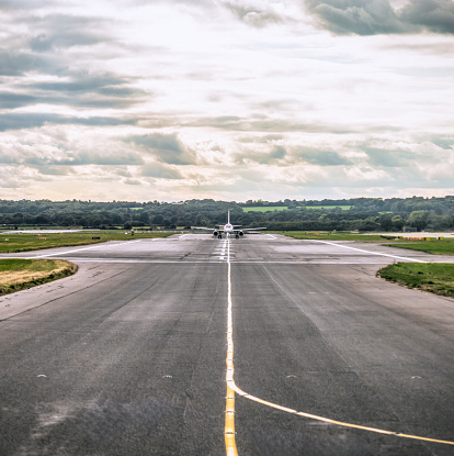 A distant plane on the runway tarmac at London's Gatwick Airport.