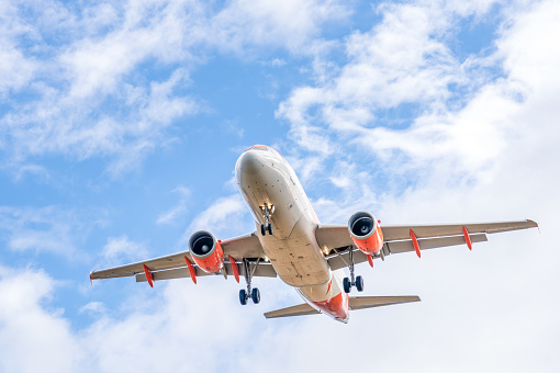 A view from below a commercial plane with its landing gear down as it comes in to land at the airport.