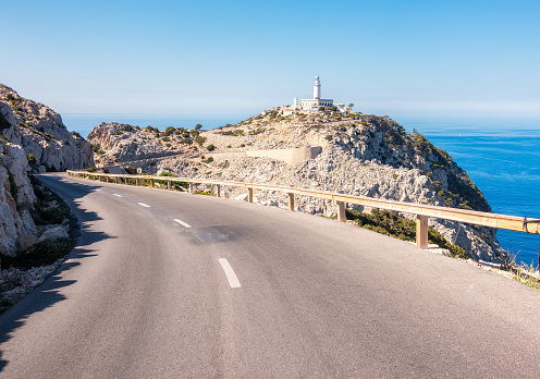 A winding mountain road leading out to the Cap Formentor Lighthouse on the Balearic island of Majorca.