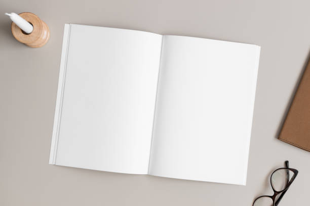 istock Open magazine mockup with a candle and workspace accessories on the beige table. 1954566427