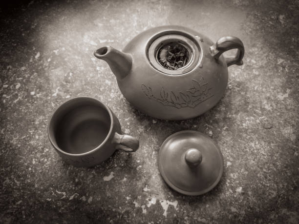 Clay teapot and teacup on travertino marble. Close-up