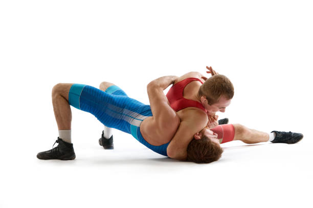 gréco-romaine, lutte libre. deux sportifs, se battant en uniforme rouge et bleu en action sur fond de studio blanc. - greco roman photos et images de collection