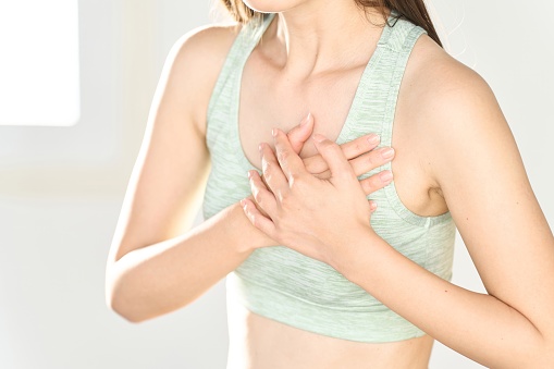 A woman hurts her chest while training