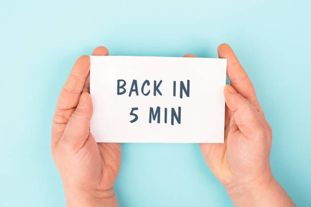 istock Back in 5 min is standing on a paper, hands hold message, working break, be right back 1954599884