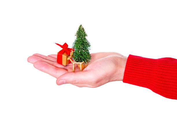 istock Miniature Christmas Scene Nestled in Hand on White 1954615753