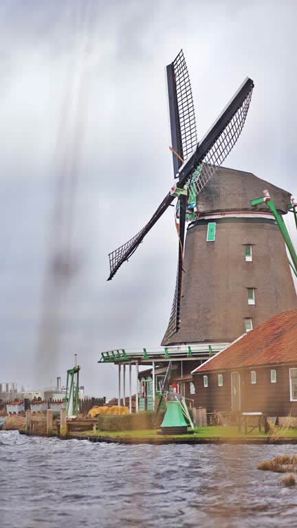 Traditional windmills in Zaanse Schans in the Netherlands, Spinning mills, Rural landscape with windmills in the Netherlands, Ancient wooden windmills in Zaanse Schans, the most popular tourist attraction in the Netherlands