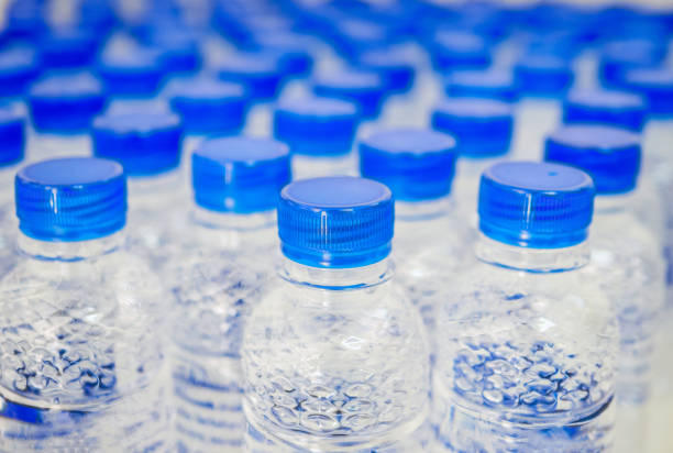 istock Many blue drinking water bottle caps and pure drinking water bottles in a drinking water production plant. 1954630566