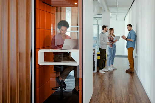 African american female Freelance entrepreneur working from co working office booth