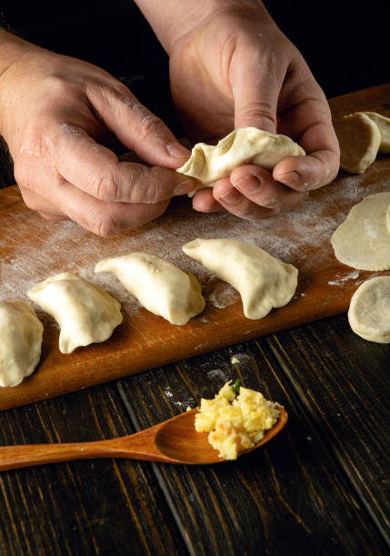 istock The chef makes a dumpling from dough and potatoes with his hands. Concept of preparing delicious dumplings on the kitchen table for lunch 1954633350