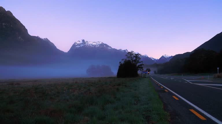 The Road trip view of  travel with mountain view of autumn scene and  foggy in the morning with sunrise sky scene at fiordland national park