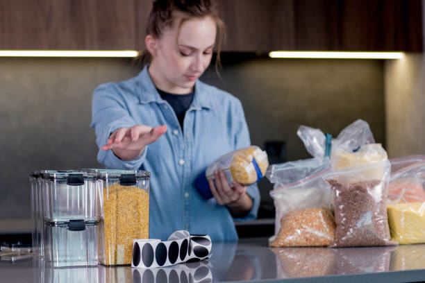 istock Happy woman professional space organizer smiling posing with plastic case boxes for comfortable product storage.Management of the organization in the interior of a modern kitchen 1954654750