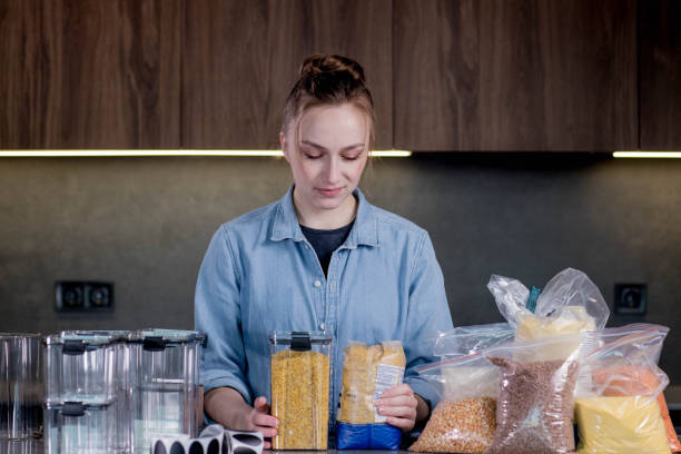 istock Happy woman professional space organizer smiling posing with plastic case boxes for comfortable product storage.Management of the organization in the interior of a modern kitchen 1954654751