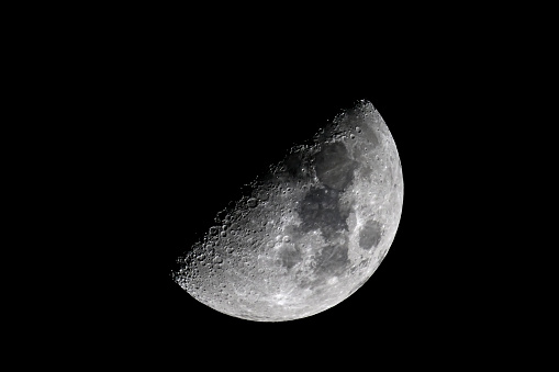 Partly illuminated moon in the dark night sky over Western Europe on January 18, 2024. The surface of the moon is clearly visible with various craters and seas.