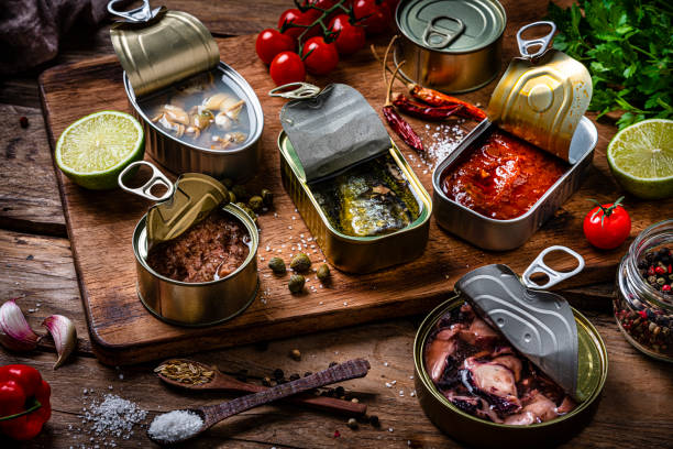istock Composition of a group of open seafood cans shot on rustic wooden table 1954682649