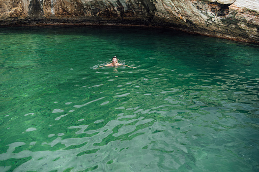 Young woman swimming in natural pool Giola on Thassos island, Greece