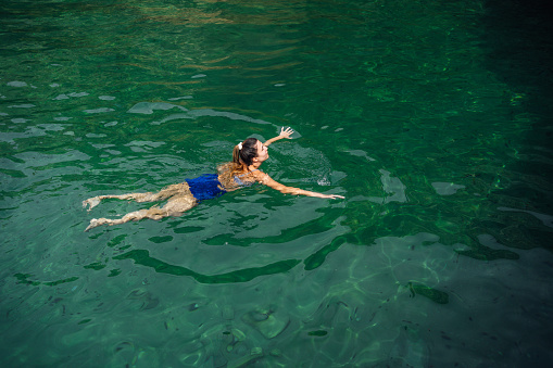 Young carefree woman swimming in the sea
