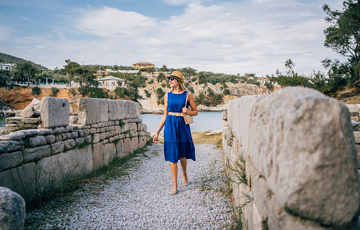 A female tourist visiting ruins of an ancient village in the archaeological site of Aliki on Thasos island
