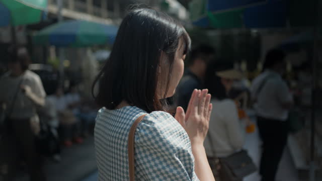 Asian woman praying at Erawan Shrine