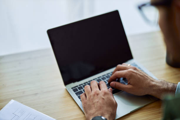 istock Close-up on man's hands using a laptop for modern work and typing on its keyboard. 1954701082