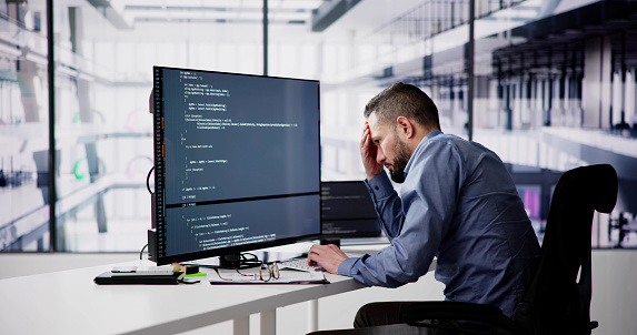 Unhappy Sad Developer Programmer Man In Stress Coding Software On Computer