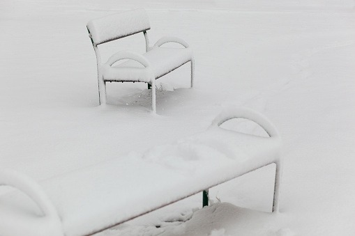 Park bench covered in fresh deep snow
