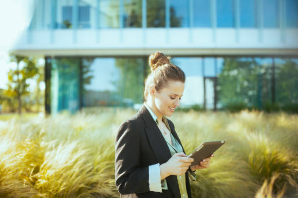 istock smiling woman worker in business district using tablet PC 1954714678