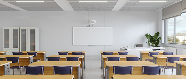 desks in a classroom with notebooks and pens, with no people occupying the seats.