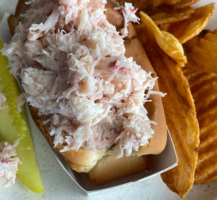 Crab roll with chips and a pickle