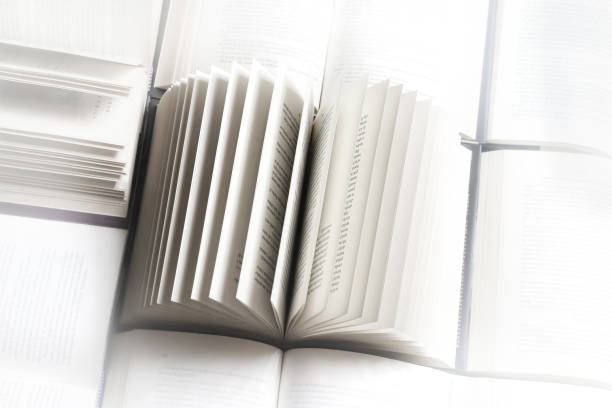 istock stack of books, close up. Open book on the table in library. Back to school concept. Open book on table with blur bookshelf background 1954764227
