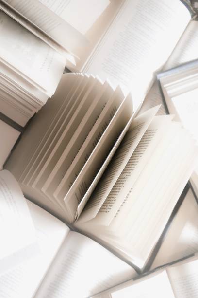 istock stack of books, close up. Open book on the table in library. Back to school concept. Open book on table with blur bookshelf background 1954764769