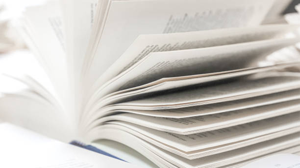 istock stack of books, close up. Open book on the table in library. Back to school concept. Open book on table with blur bookshelf background 1954767500