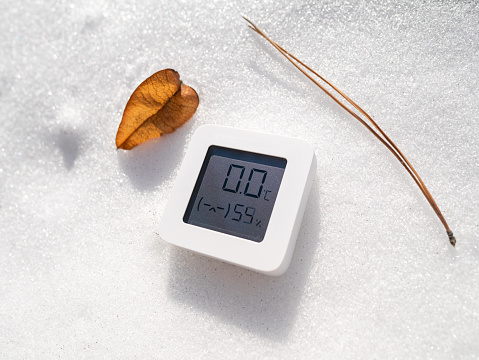 Thermometer is on the snow in winter