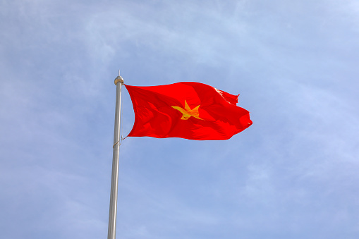 Real National Flag of Vietnam with blue sky.