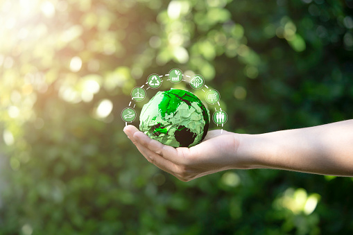 Businessman holding green scrap paper ball with world map and environment icon such as carbon reduction green factory recycle and solar cell for zero carbon emission credit to prevent global warming.