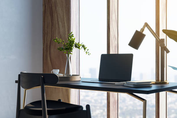 istock Contemporary designer desktop with mock up laptop, various objects and window with city view in the background. 3D Rendering. 1954850790