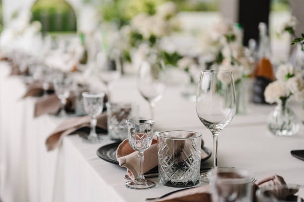 istock Serving, setting table in the backyard. Plate and glass, stack, wineglass, luxury rich decor. Wedding set up, dinner table reception on terrace. Birthday, baptism, event. Closeup details of interior. 1954864171