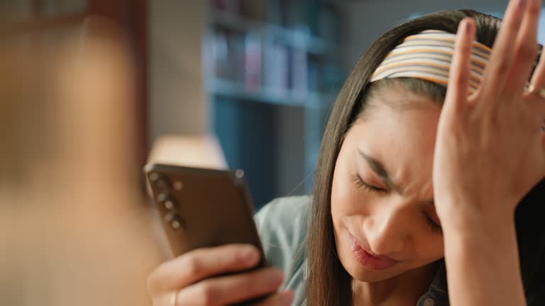 Phone, stress or headache and face of woman in home with anxiety about debt or closeup. Pain, migraine and eye strain with young person browsing social media or reading information on mobile app