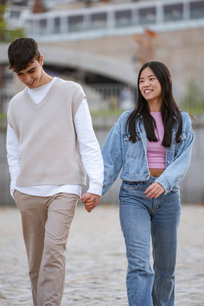 istock Couple holding hands and smiling while enjoying a walk together. 1954931319