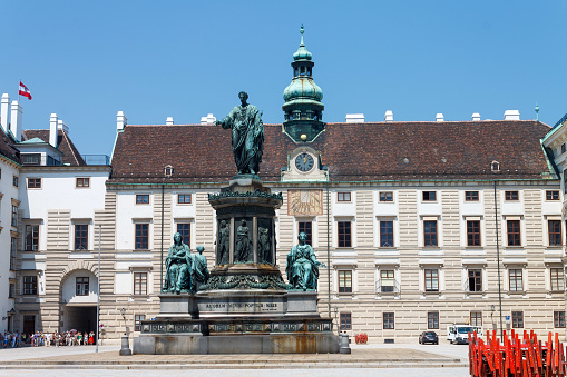 Vienna, Austria, - June, 20, 2013: Emperor Fracins I bronze monument and a clock tower in Hofburg palace, Vienna, Austria
