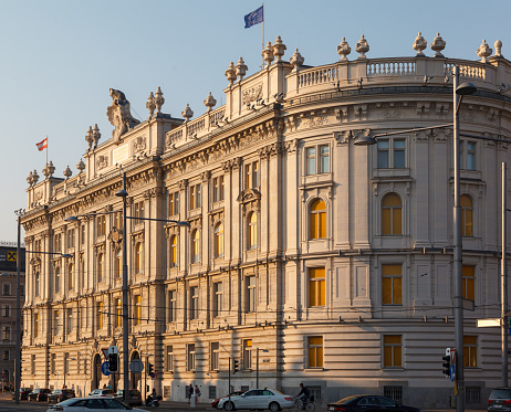 The King is in, the Royal's flag is flying over their mansion. Two Guards are visible in their guard kiosks, there are many more around the building, the grounds of which are open to the general public.