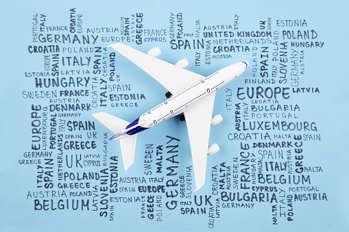 Airplane and word cloud with Europe countries on blue background